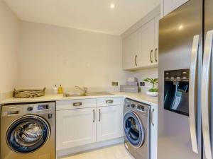 a kitchen with white cabinets and a washer and dryer at 2 Bed in Skipton oc-82602 in Buckden