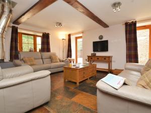 a living room with two couches and a tv at 4 Bed in Sherborne oc-folow in Long Burton