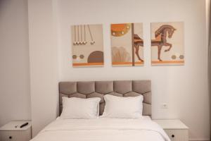 a bedroom with a bed with three pictures on the wall at Id-Real Villa in Golem +291 photos