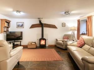 a living room with a fireplace and a couch at 3 Bed in Sherborne oc-folwr in Long Burton
