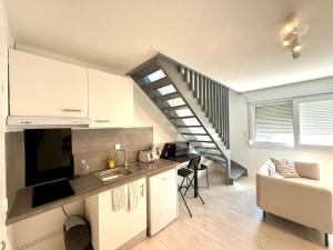a kitchen and living room with a staircase in the background at Appartement calme parking in Le Monastère