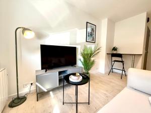 a living room with a large flat screen tv at Appartement calme parking in Le Monastère