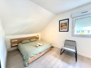 a bedroom with a bed and a chair in it at Appartement calme parking in Le Monastère