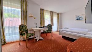 a hotel room with a bed and a table and chairs at Flexibel Wohnen - BnoB in Füssen +13 photos