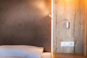 a bedroom with a bed with a light on the wall at Hotel Christine in Gargazzone