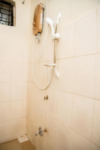 a shower in a bathroom with a phone on the wall at Chuma's home in Arusha
