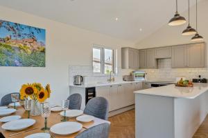 a kitchen with a table and chairs and a kitchen with white cabinets at 3 Bed in Adgestone oc-a32613 in Brading