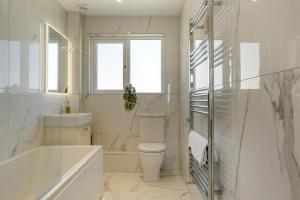 a bathroom with a tub and a toilet and a sink at 3 Bed in Adgestone oc-a32613 in Brading +32 photos