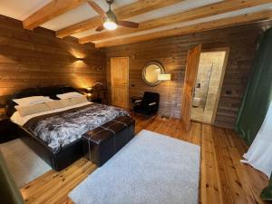 a bedroom with a bed in a room with wooden walls at Carpathian Log Home in Bran