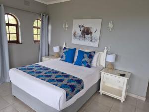 a bedroom with a large bed with blue pillows at Fairway Guest Lodge in Margate +177 photos
