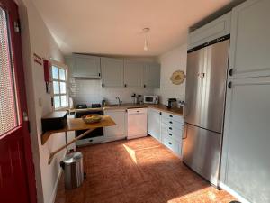 a kitchen with white cabinets and a stainless steel refrigerator at Refúgio Alentejano in Estremoz