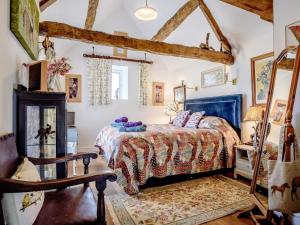 a bedroom with a bed and a chair in a room at 2 Bed in Lechlade oc-77493 in Langford