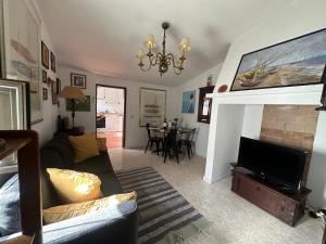 a living room with a couch and a television at Refúgio Alentejano in Estremoz