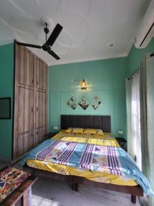 a bedroom with a large bed with green walls at Nature View Homestay in Dehradun