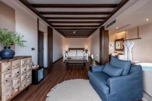 a bedroom with a blue couch and a bed at Maison lyly 300 Year Historical Cultural Courtyard and Ancient City View in Lijiang