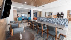 a restaurant with tables and chairs and a tv at Holiday Inn Express Hotel & Suites Anderson by IHG in Anderson