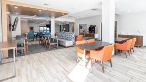 a dining room with tables and chairs in a cafeteria at Holiday Inn Express Hotel & Suites Anderson by IHG in Anderson