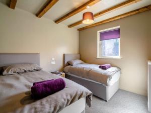 two beds in a room with purple pillows at 2 Bed in Lancaster oc-53510 in Beetham