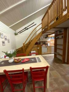 a kitchen with a table with red chairs and a staircase at Apartmany U vleku 6 in Ceske Petrovice