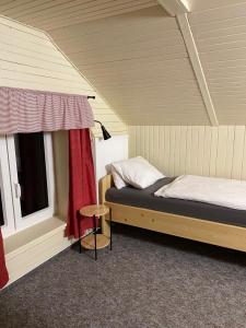a room with a bed and a window and a stool at Apartmany U vleku 6 in Ceske Petrovice