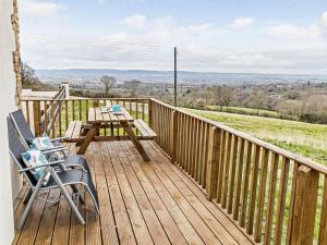 a wooden deck with a table and a chair on it at 2 Bed in Wellington oc-56950 in West Buckland +9 photos