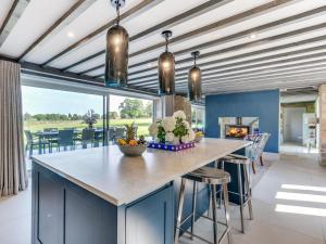 a kitchen with blue cabinets and a large island with bar stools at 6 Bed in Richmond oc-80466 in Gilling