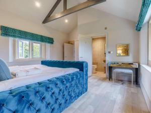 a large blue bed in a room with a bathroom at 6 Bed in Richmond oc-80466 in Gilling