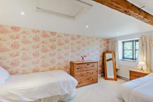 a bedroom with two beds and a dresser and a mirror at 2 Bed in Askrigg oc-b27667 in Marsett