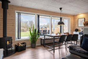 a living room with a table and a fireplace at LF127-Vestervig-Gunhildsvej-27 in Vestervig +19 photos