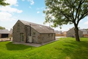 an old stone barn with a tree in the yard at 4 Bed in Buxton oc-dcoldd in Hartington