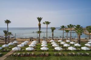 a group of white umbrellas and chairs on the beach at Atlantica Callisto in Ayia Napa