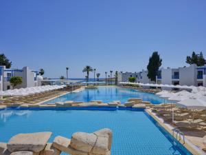 a swimming pool with chairs and umbrellas at a resort at Atlantica Callisto in Ayia Napa