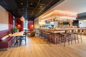 a bar in a restaurant with tables and chairs at Best Western Hôtel du Phare in Mérignac