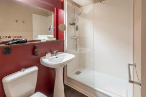 a bathroom with a toilet and a sink and a shower at Best Western Hôtel du Phare in Mérignac +52 photos
