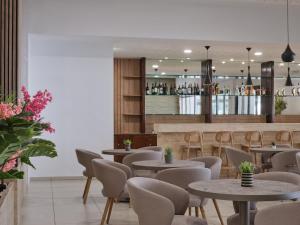 a restaurant with tables and chairs and a bar at Atlantica Callisto in Ayia Napa