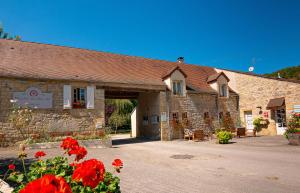 a stone building with red flowers in front of it at Glamping Saint Germain in Saint-Germain-du-Bel-Air