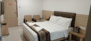 a bedroom with a large bed with white sheets and pillows at Ango Plaza Hotel in Kovilpatti