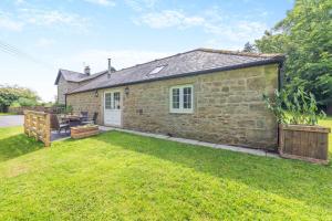 a stone house with a lawn in front of it at 2 Bed in Belsay oc-t29653 in Bolam +18 photos