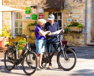 a man and a woman standing next to a bike at Glamping Saint Germain in Saint-Germain-du-Bel-Air