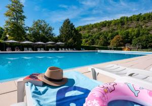 a hat sitting on a chair next to a swimming pool at Glamping Saint Germain in Saint-Germain-du-Bel-Air