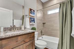 a bathroom with a toilet and a sink and a tub at The Tipsy Twins - Entire Property in Canyon Lake +38 photos