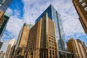 a tall glass building in the middle of a city at Metcalfe Hotel Montréal by Gray Collection in Montreal