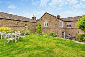 a garden with a table and chairs in front of a house at 3 Bed in Askrigg oc-h29661 in Askrigg