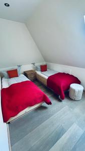 a bedroom with a red comforter and a bed at Min Ithüus in Rantum