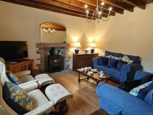 a living room with blue couches and a fireplace at 3 Bed in Askrigg oc-w29833 in Marsett