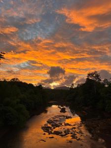 a sunset over a river with a cloudy sky at Ban Suan Chana Homestay in Ban Pha Saeng Lang +4 photos