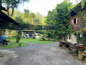 a gravel road next to a house with a tree at Ban Suan Chana Homestay in Ban Pha Saeng Lang