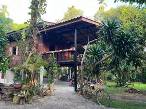 a house with a bike parked in front of it at Ban Suan Chana Homestay in Ban Pha Saeng Lang