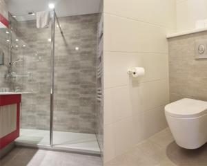 a bathroom with a toilet and a glass shower at Hotel Restaurant Au Parc des Cigognes in Kintzheim +43 photos