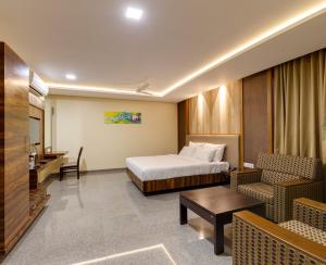 a hotel room with a bed and a table and chairs at Hotel Silver Oak 7 Minutes Walk to Mahalaxmi Temple in Kolhapur +120 photos